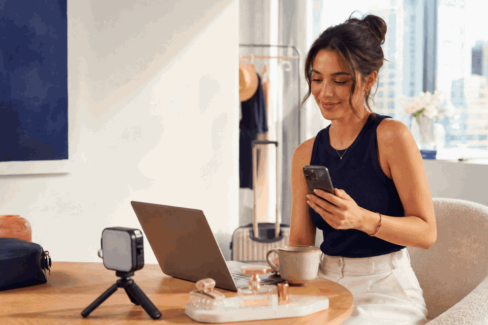 Eine Social-Media-Creatorin bereitet Smartphone-Content in einem hellen Home-Studio vor